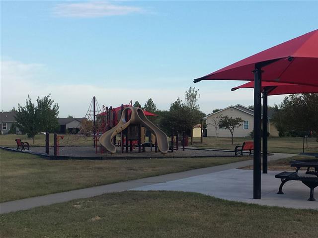 A bright red umbrella is situated in the middle of a park